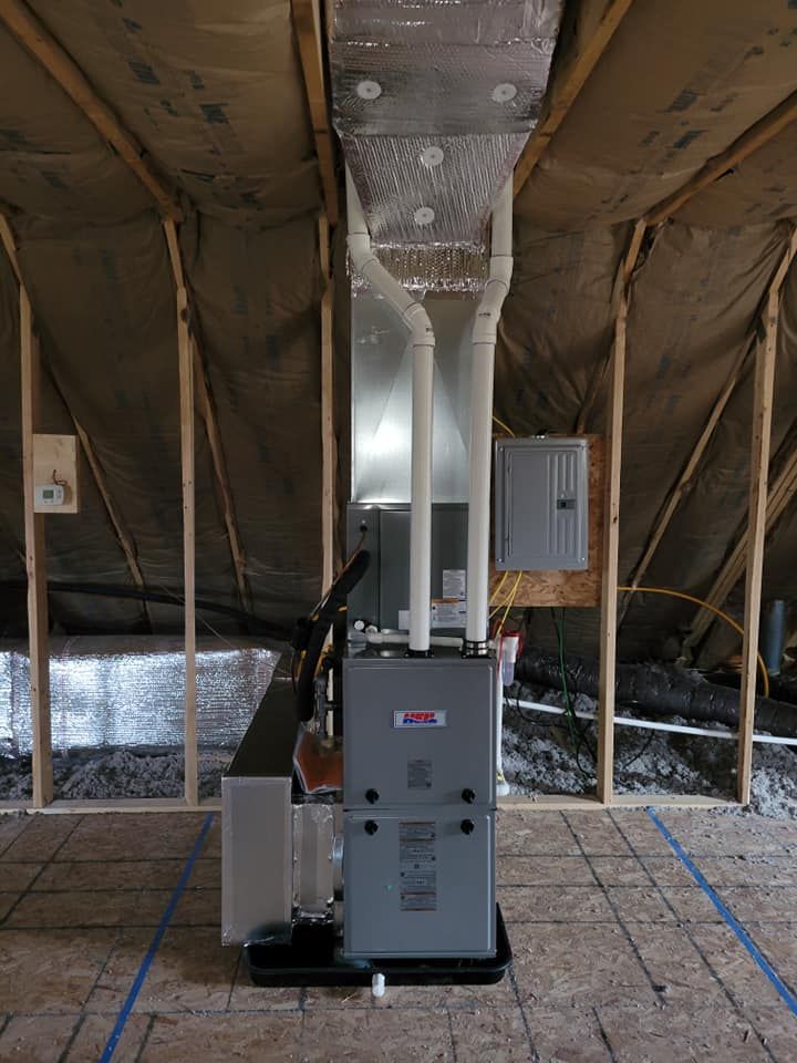 An air conditioner is sitting in the attic of a house under construction.