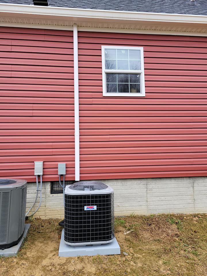 A red house with a window and an air conditioner on the side of it.