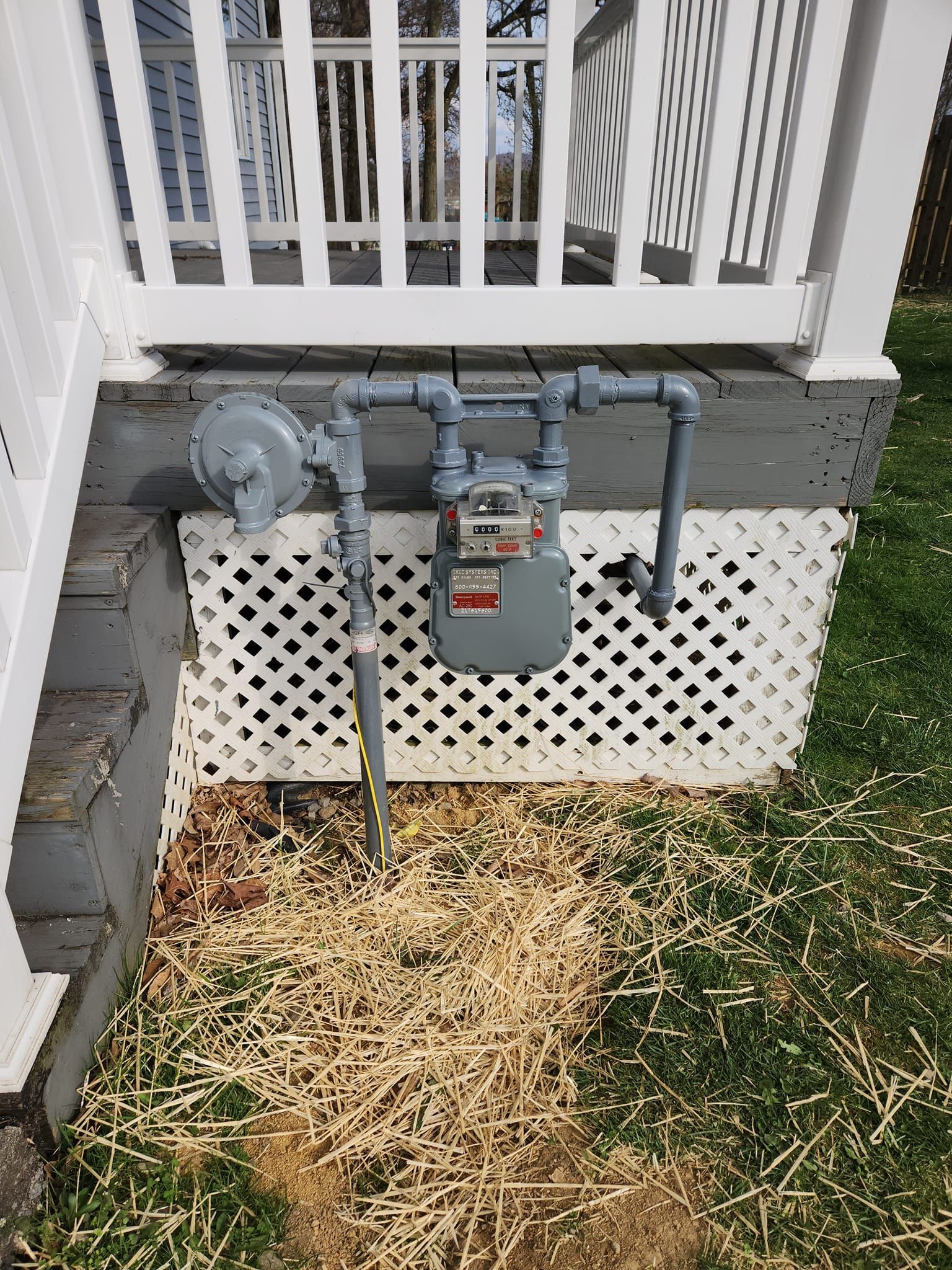 A gas meter is attached to the side of a house.