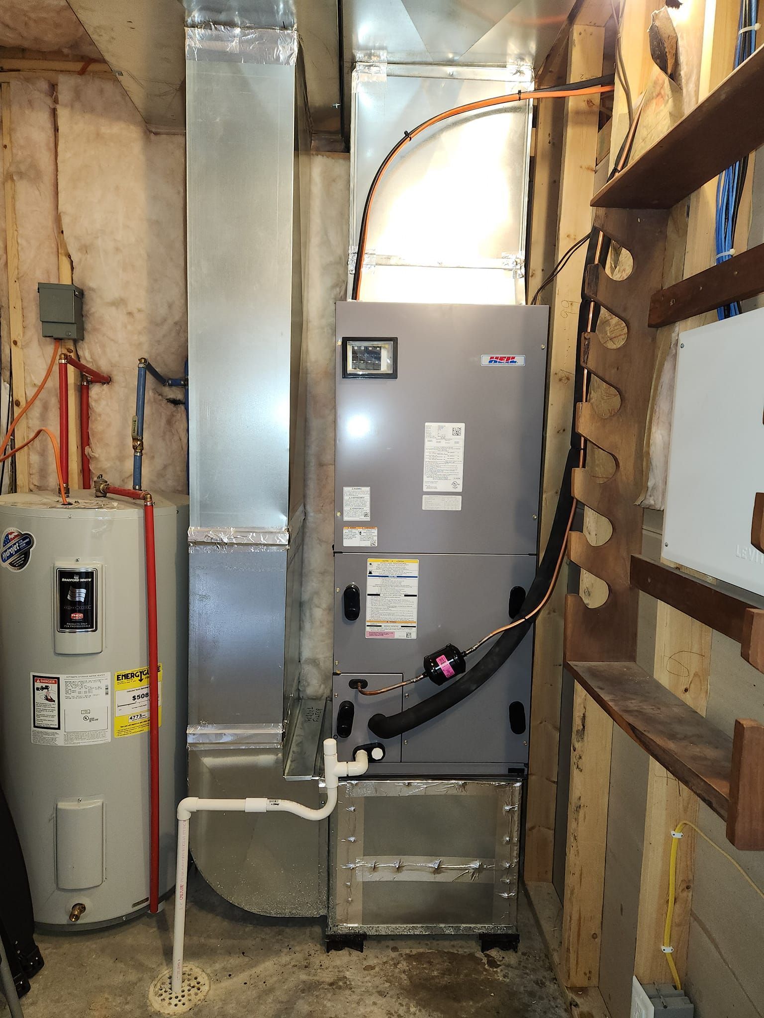 A room with a heater , water heater , and air conditioner.