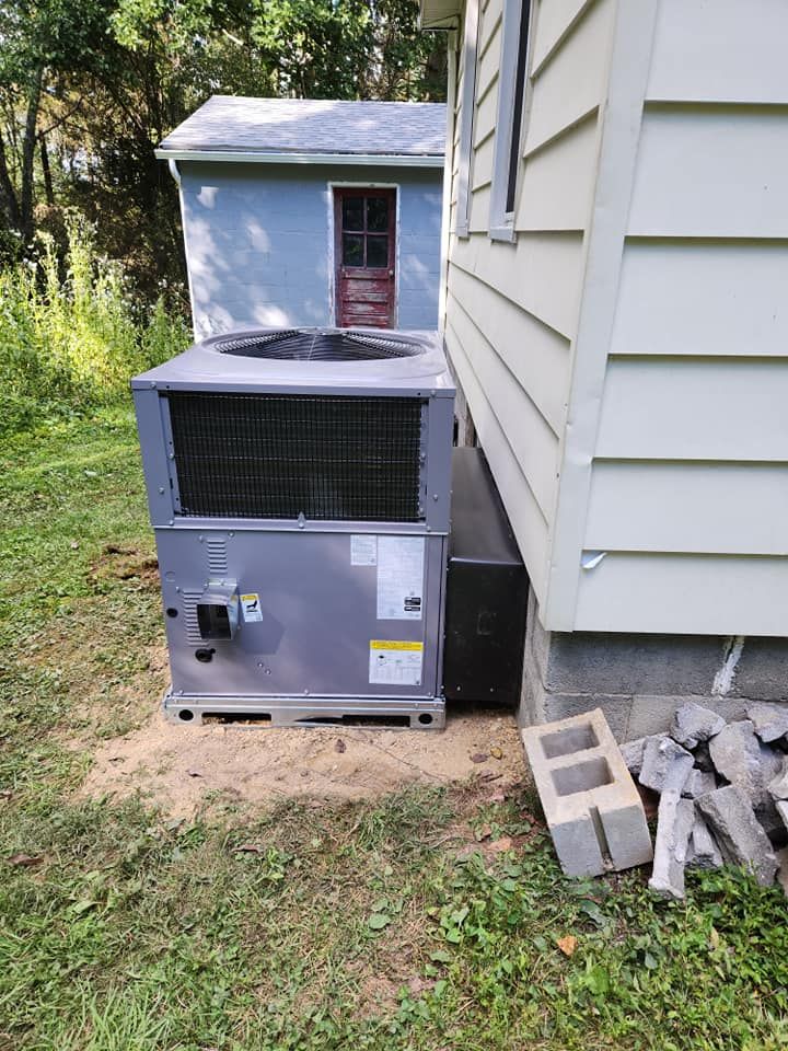 A large air conditioner is sitting on the side of a house.