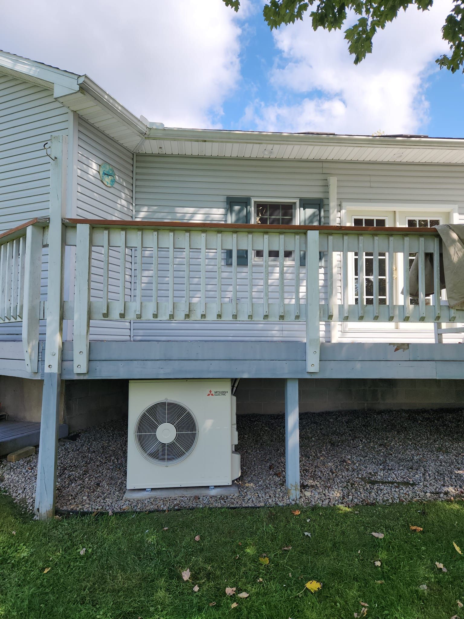 A white house with a white deck and a white fence.