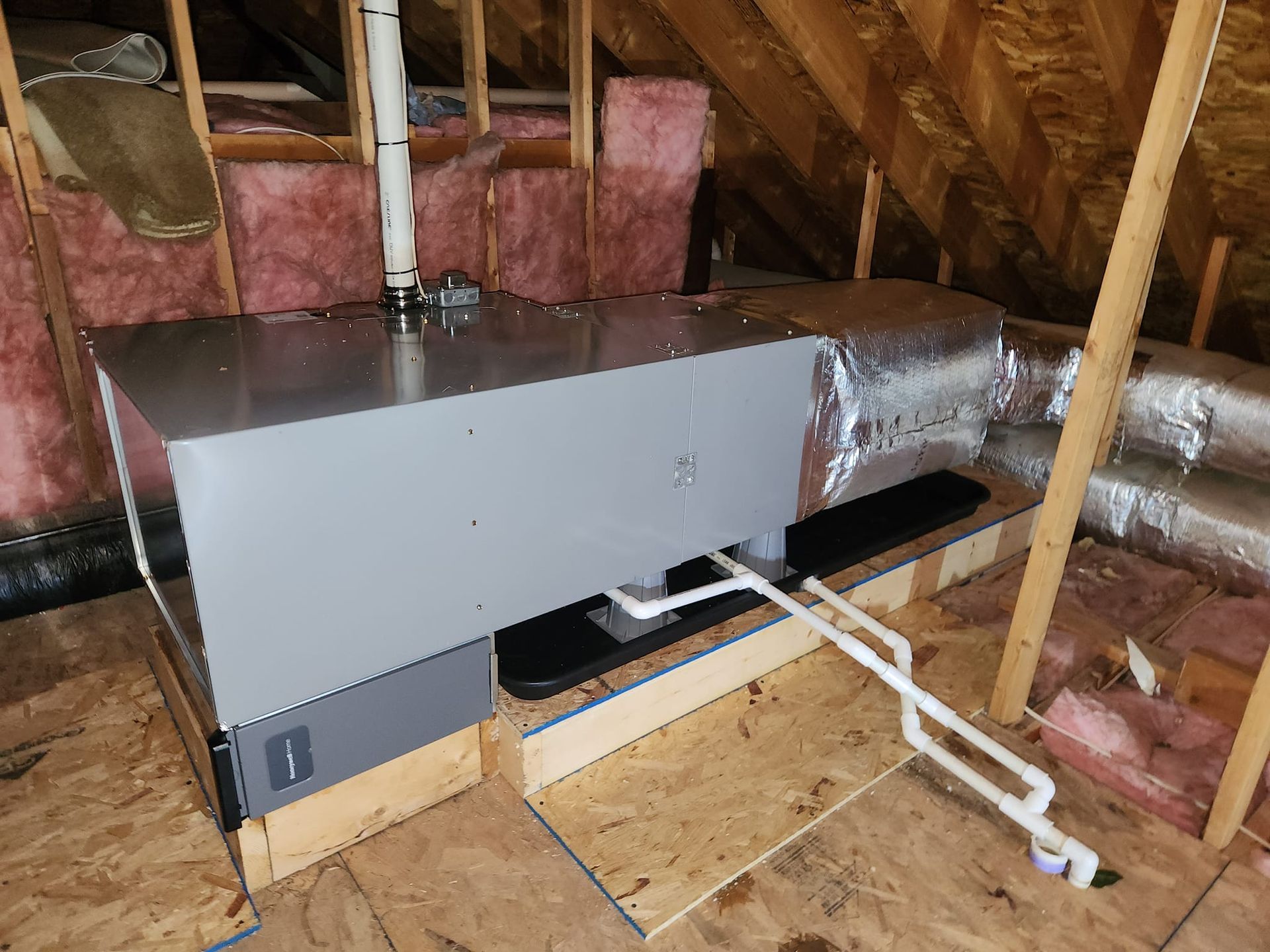 An air conditioner is installed in the attic of a house.