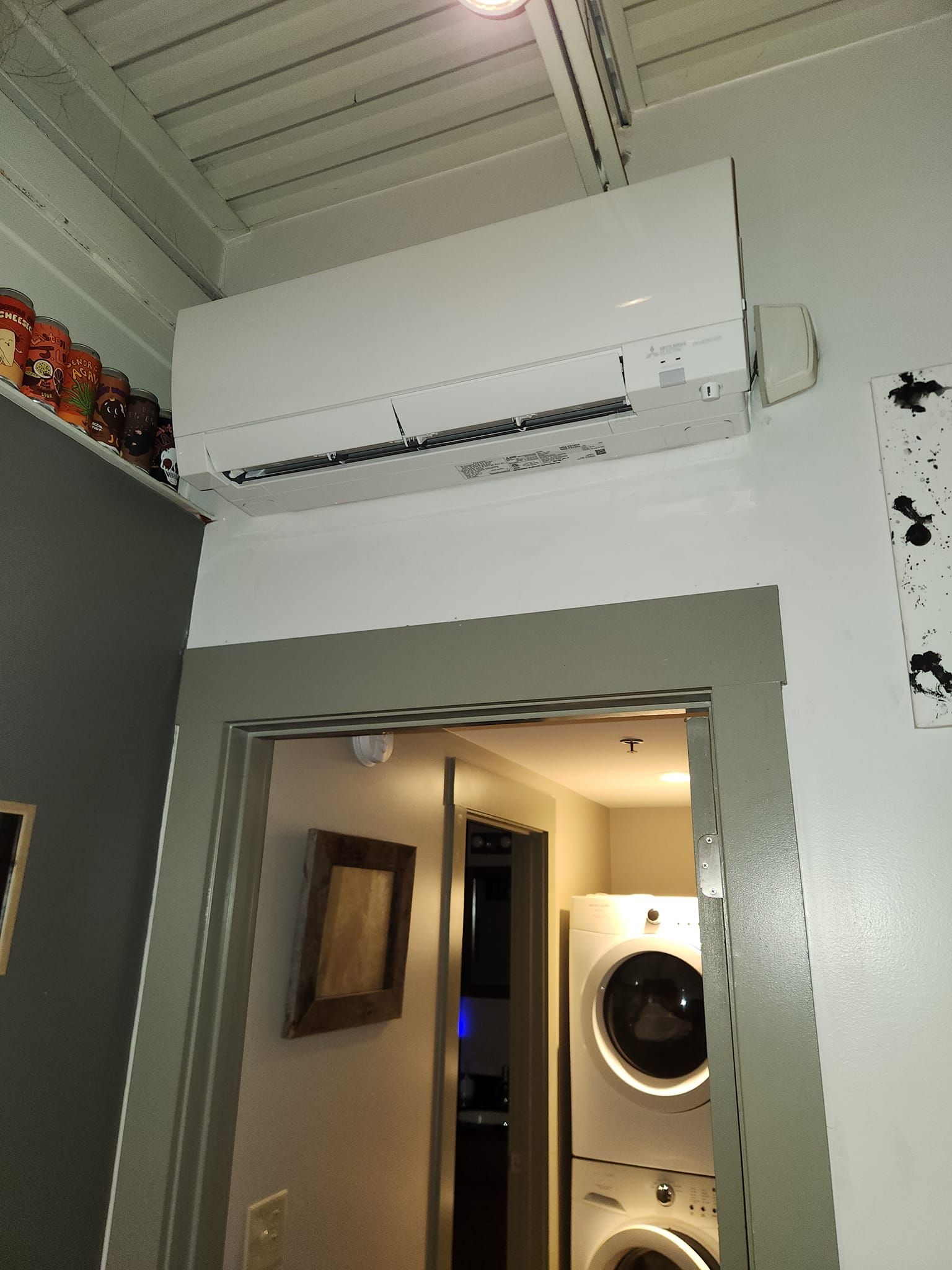 A room with a washer and dryer and a wall mounted air conditioner