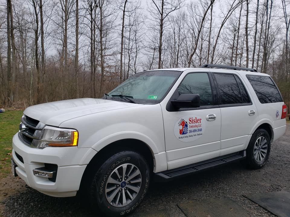 A white ford expedition is parked on the side of the road.