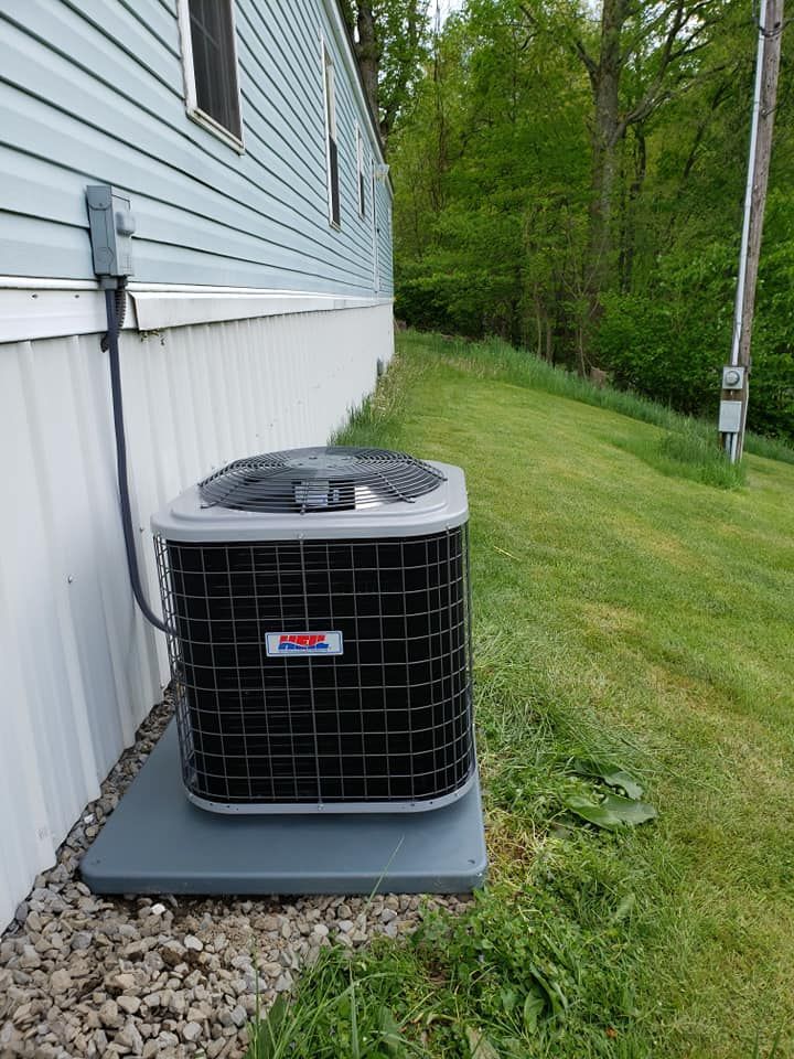 An air conditioner is sitting on the side of a house.
