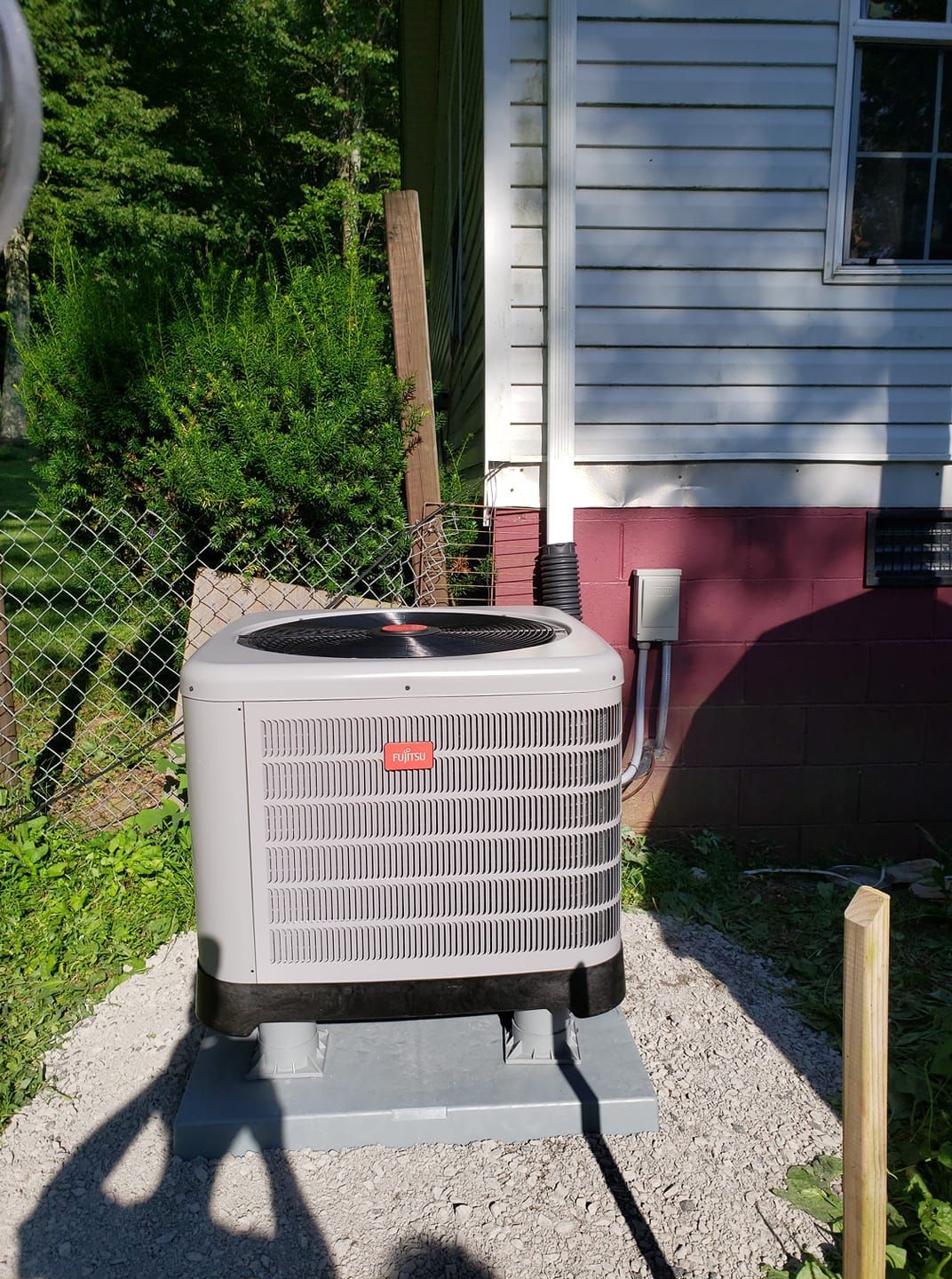 An air conditioner is sitting outside of a house.