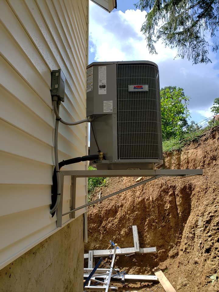 A large air conditioner is mounted on the side of a house.