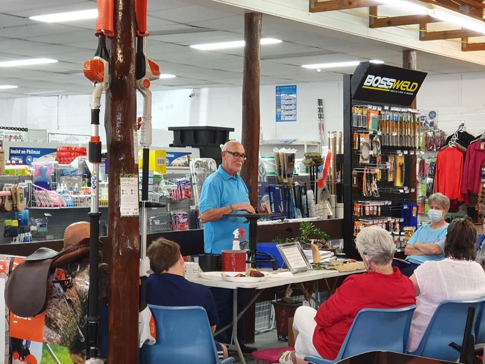 A Man Is Giving A Presentation To A Group Of People In A Store — Maleny Hardware & Rural Supplies In Maleny, QLD