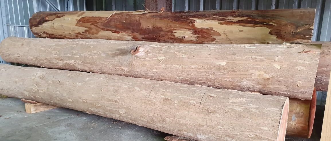 A Pile Of Logs Sitting On Top Of Each Other In A Warehouse — Maleny Hardware & Rural Supplies In Sunshine Coast, QLD