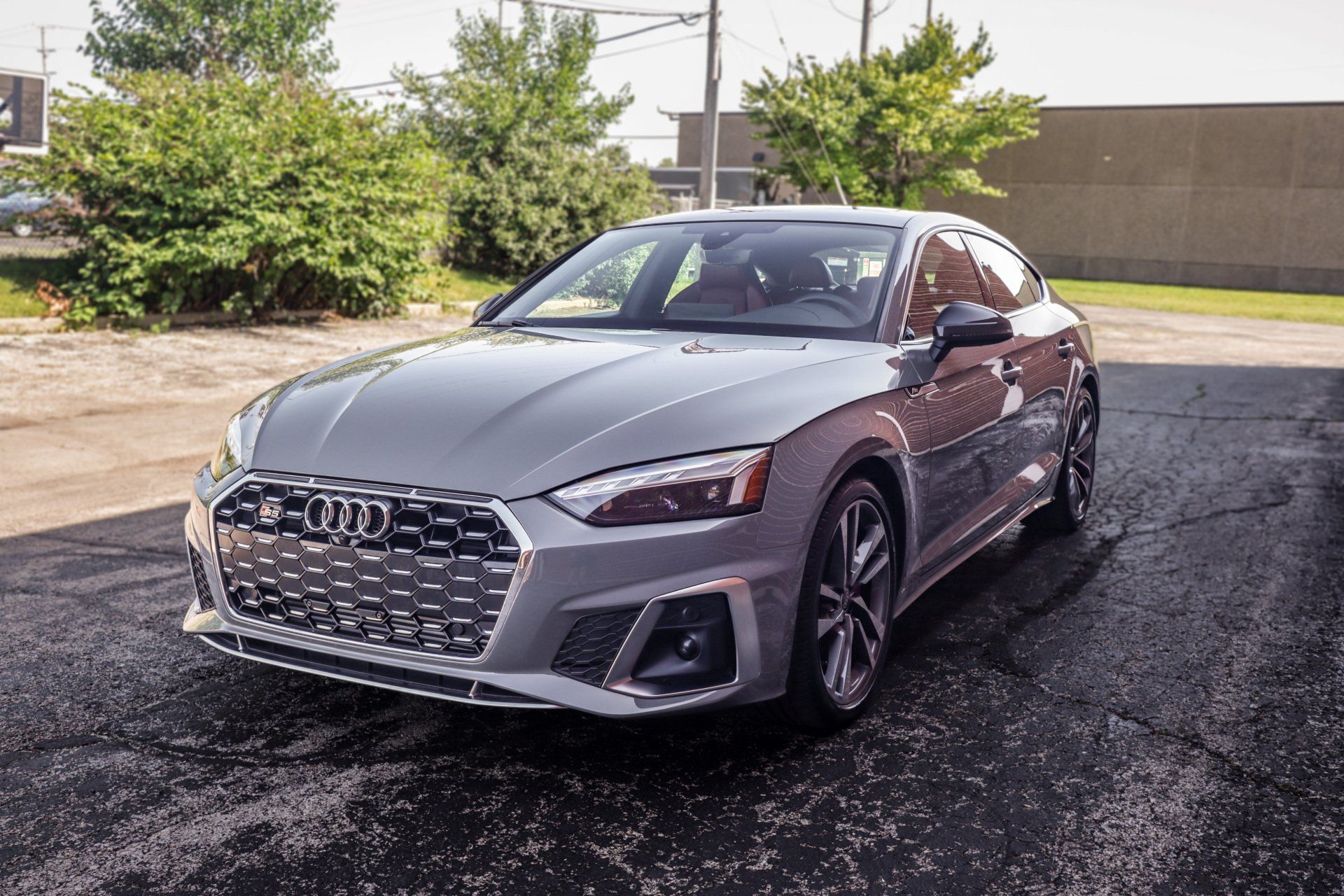 A silver audi a5 is parked in a parking lot.