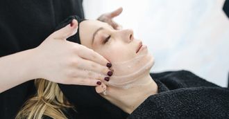 A woman is getting a facial treatment at a beauty salon.