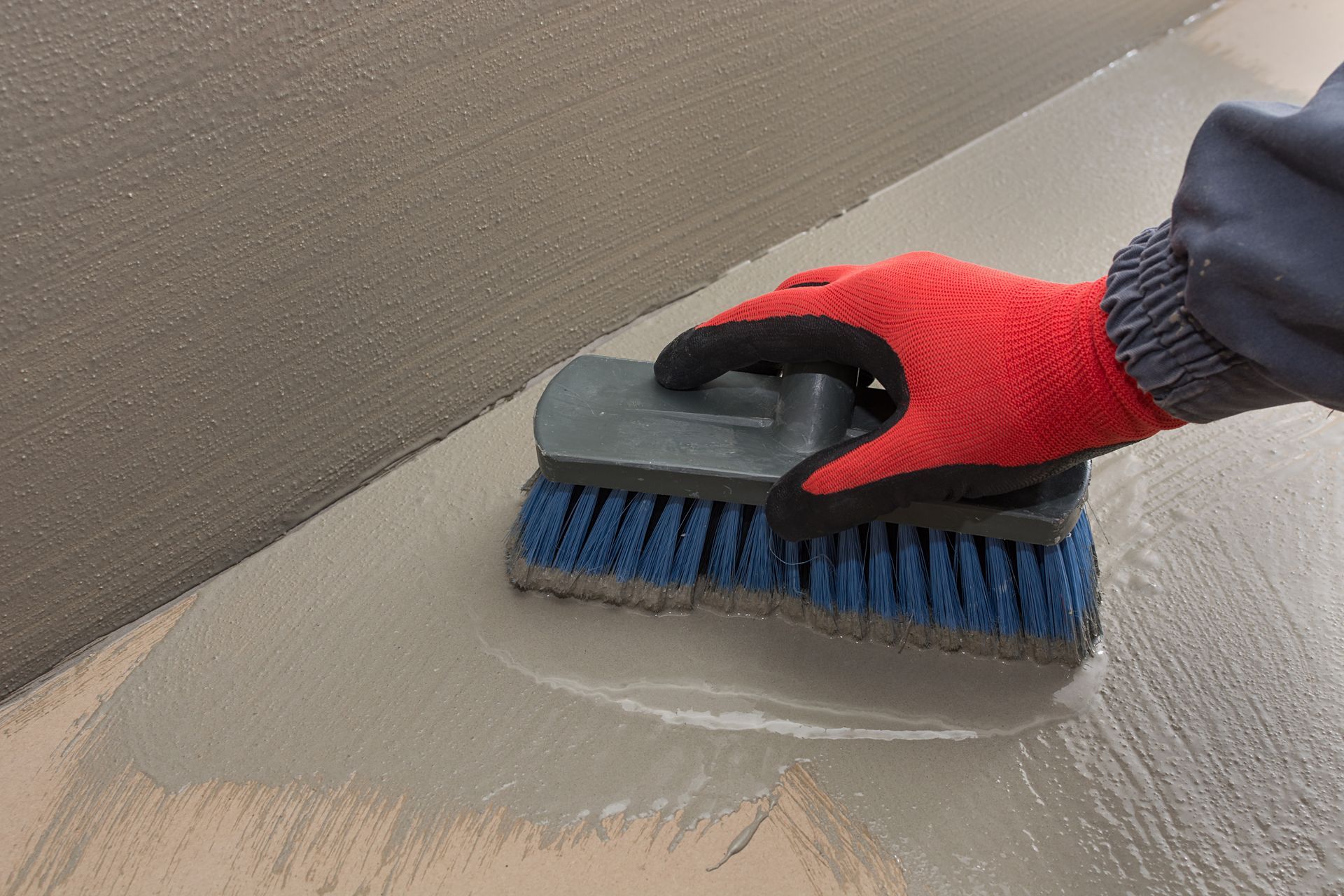 Basement waterproofing company sealing foundation wall with brush applying waterproof coating.