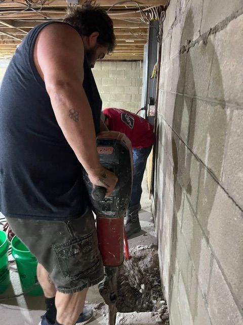 A man is using a drill to drill a hole in a wall.