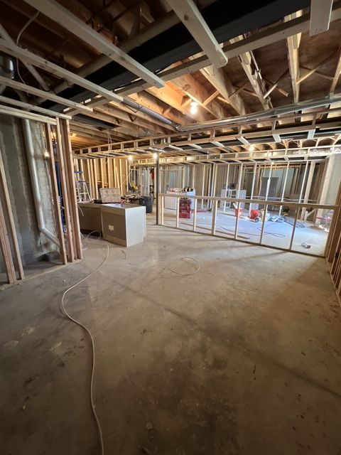 A basement under construction with a lot of windows and a concrete floor.