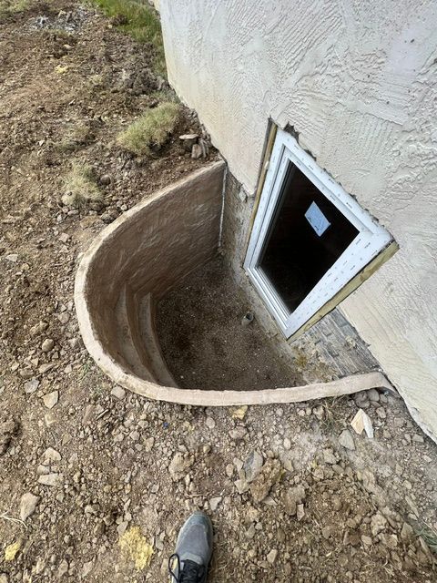 A window in the ground next to a house.