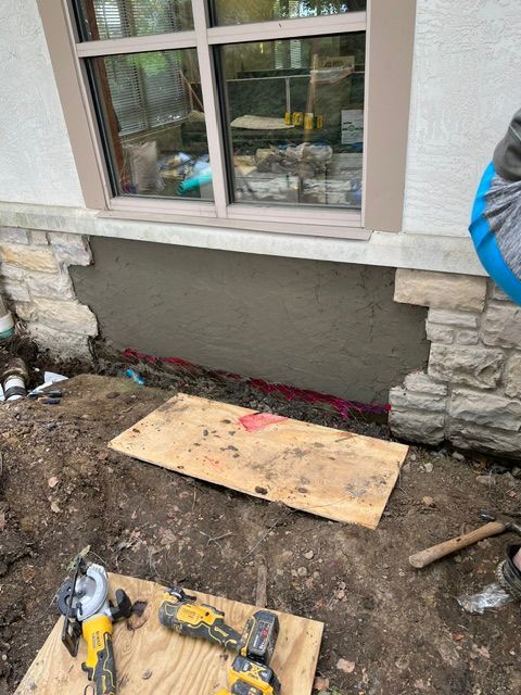 A person is working on the side of a house.