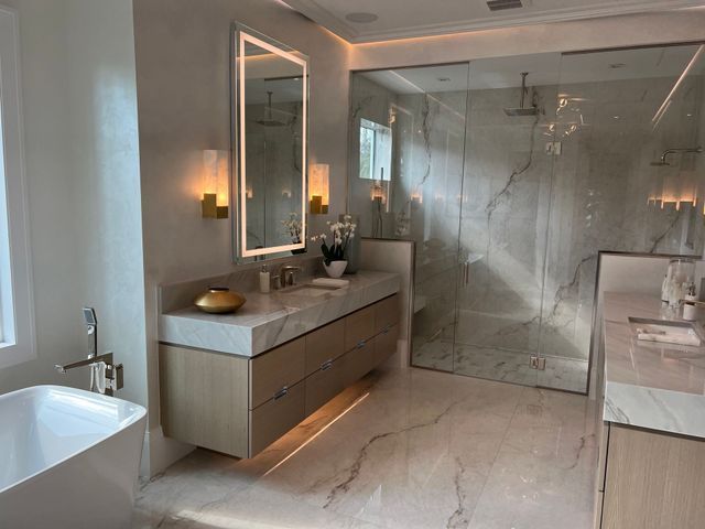 Modern bathroom with freestanding tub, double vanity, and glass-enclosed marble shower