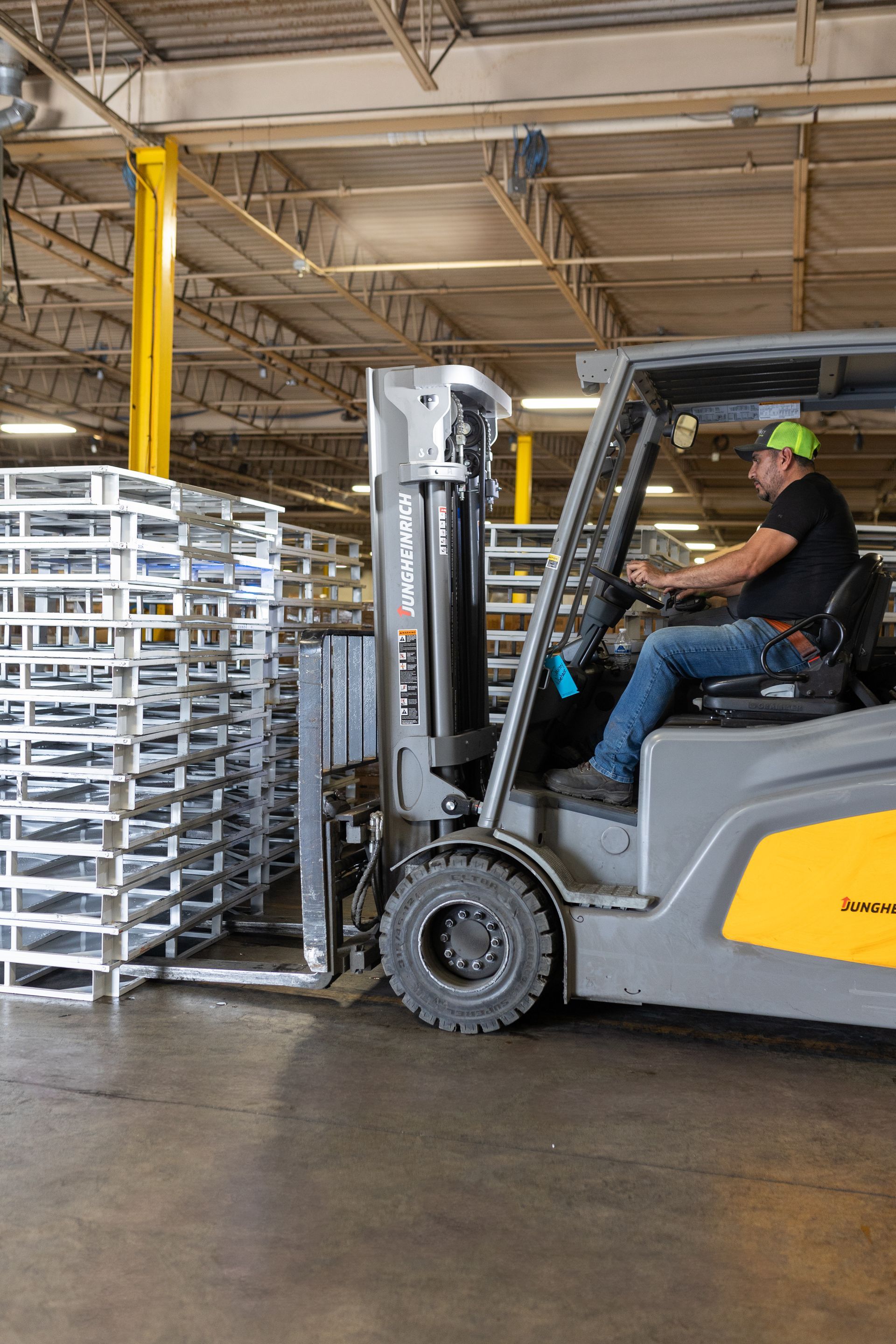 A man is driving a forklift in a warehouse.