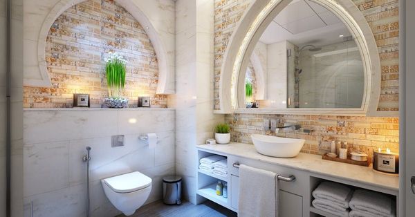 A bathroom with a toilet , sink and mirror.