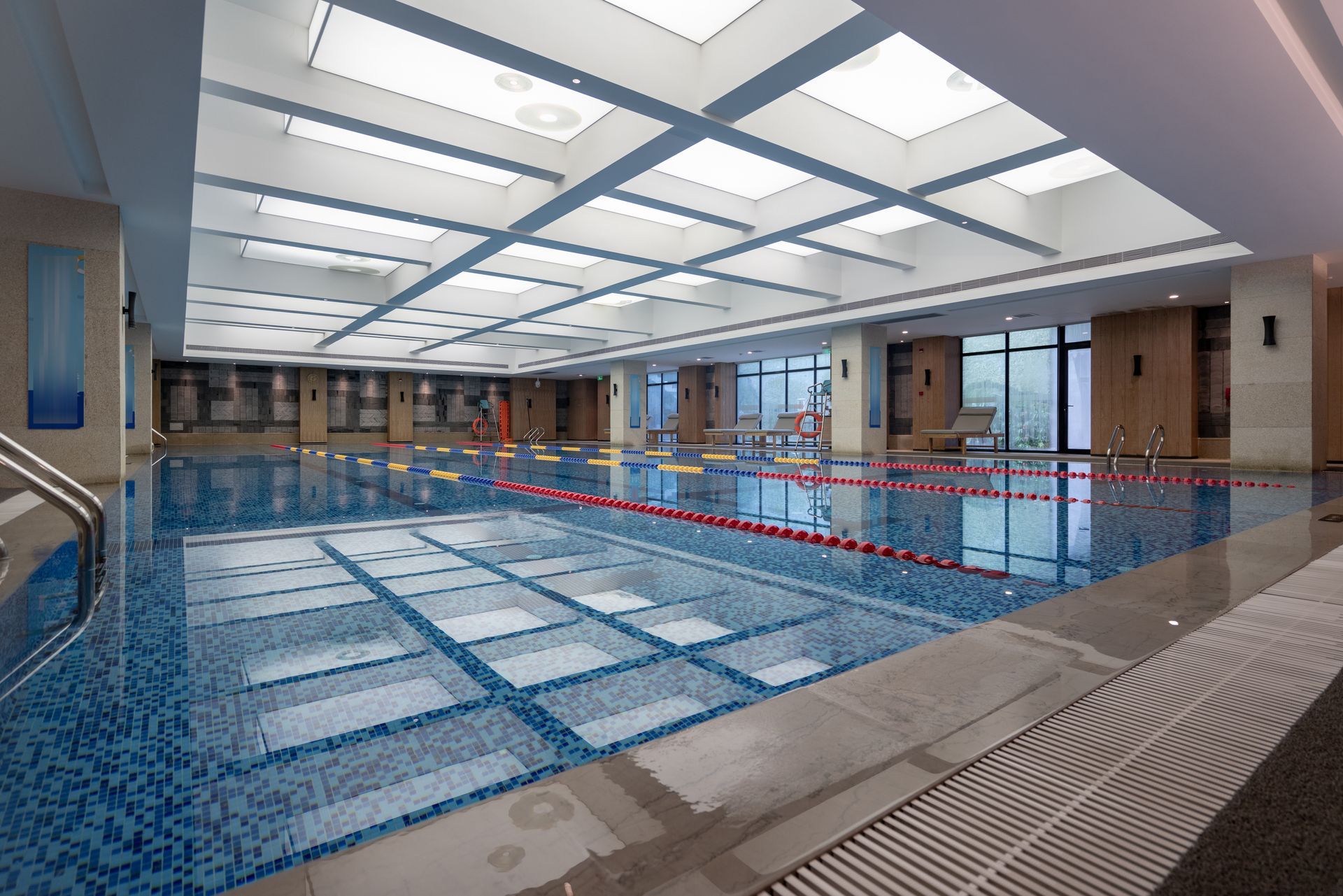 A large indoor swimming pool with a lot of windows