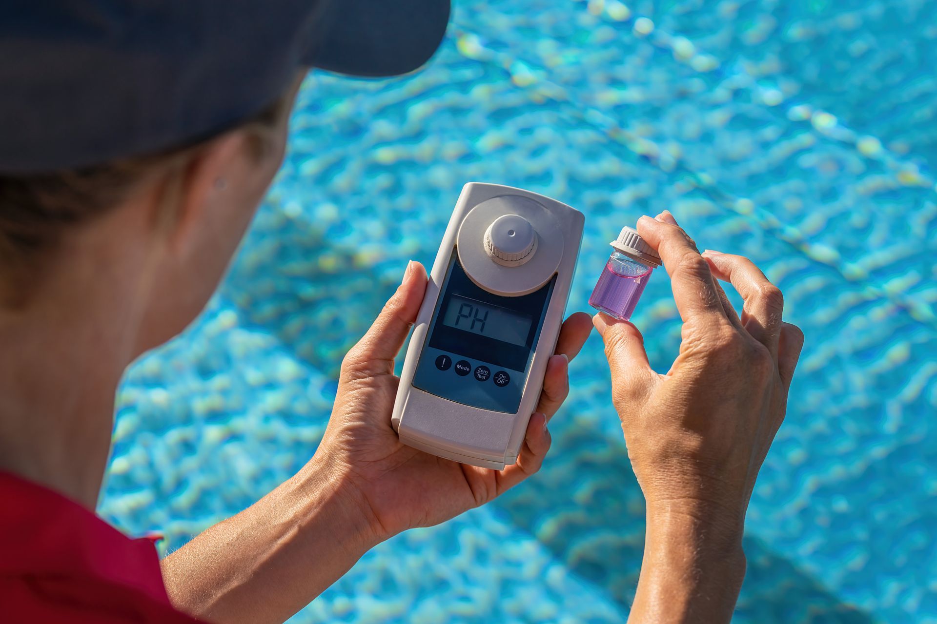 A woman is measuring the ph of a swimming pool.