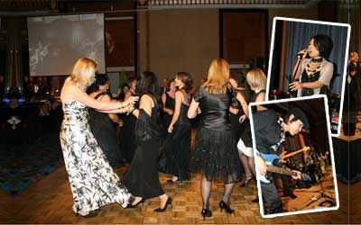 A group of women are dancing on a dance floor while a man plays a guitar.