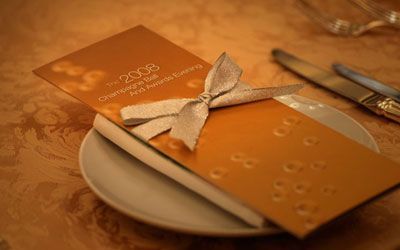 A napkin with a bow is sitting on a plate on a table.