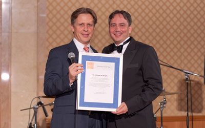 ACCJ Volunteer of the Year, Mike Wright, on stage receiving his award at the 2010 Champagne Ball