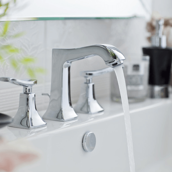 a bathroom sink tap with flowing water