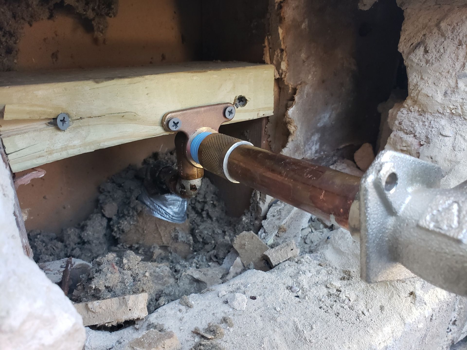 A pipe is being installed in a hole in a wall.