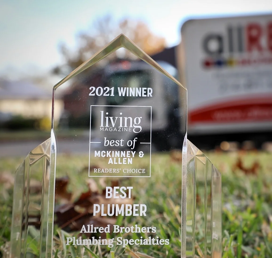 A living magazine award for best plumber is sitting in the grass.