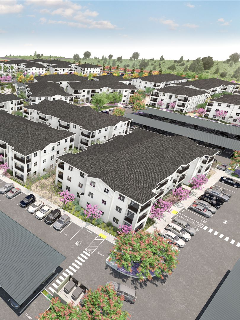 Aerial rendering of a multi-unit apartment complex with parking, landscaping, and trees.