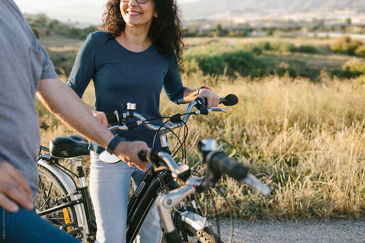 White buildings with dark roofs, cars parked in front, trees framing the sky.