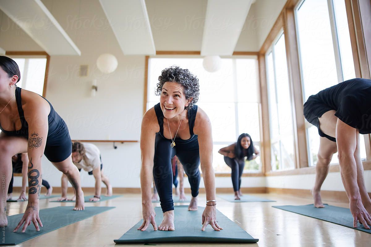 Residential complex with white buildings, pool, landscaping, and a sunny sky.