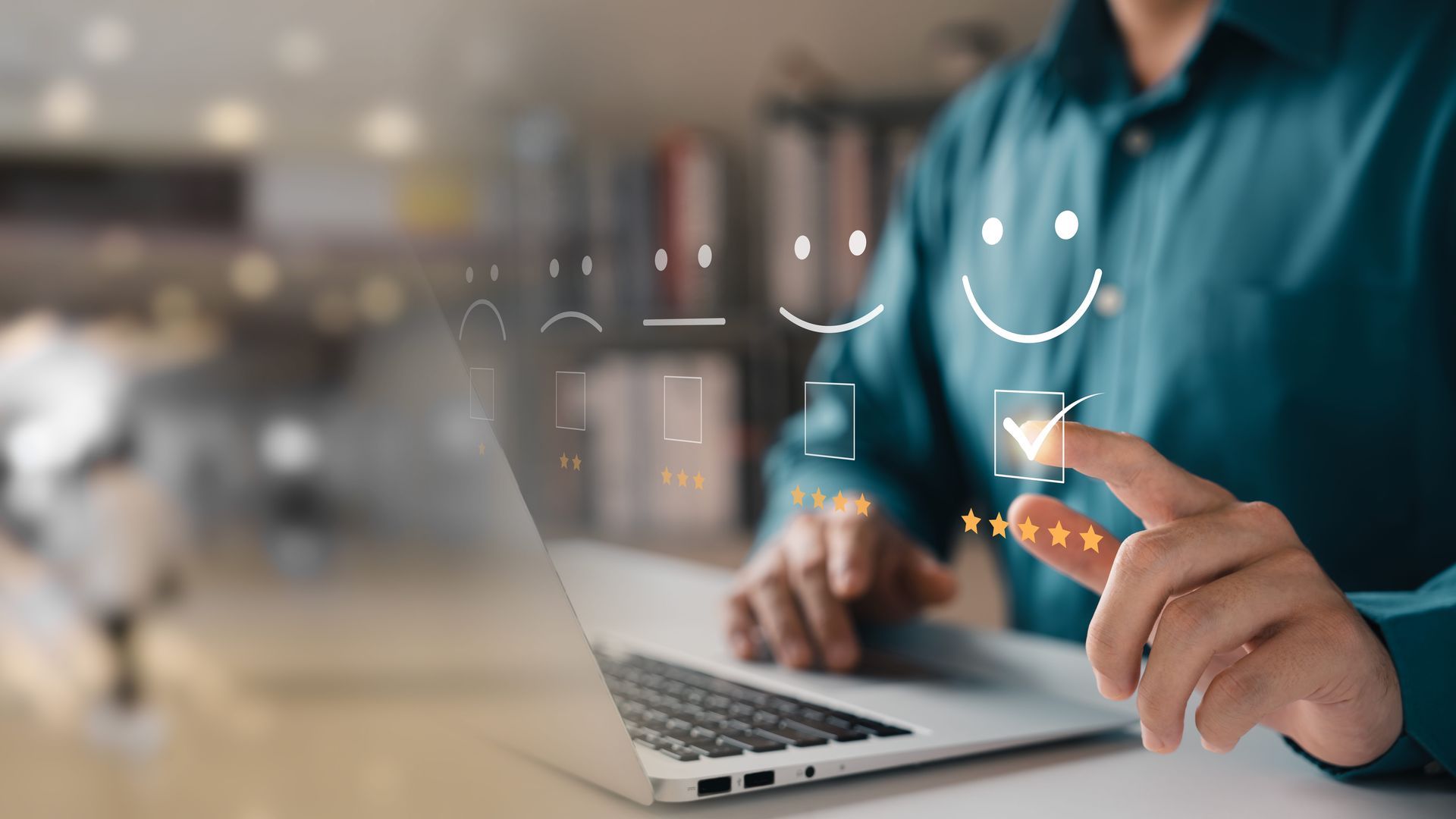 a man is sitting at a desk using a laptop computer and pointing at a smiley face