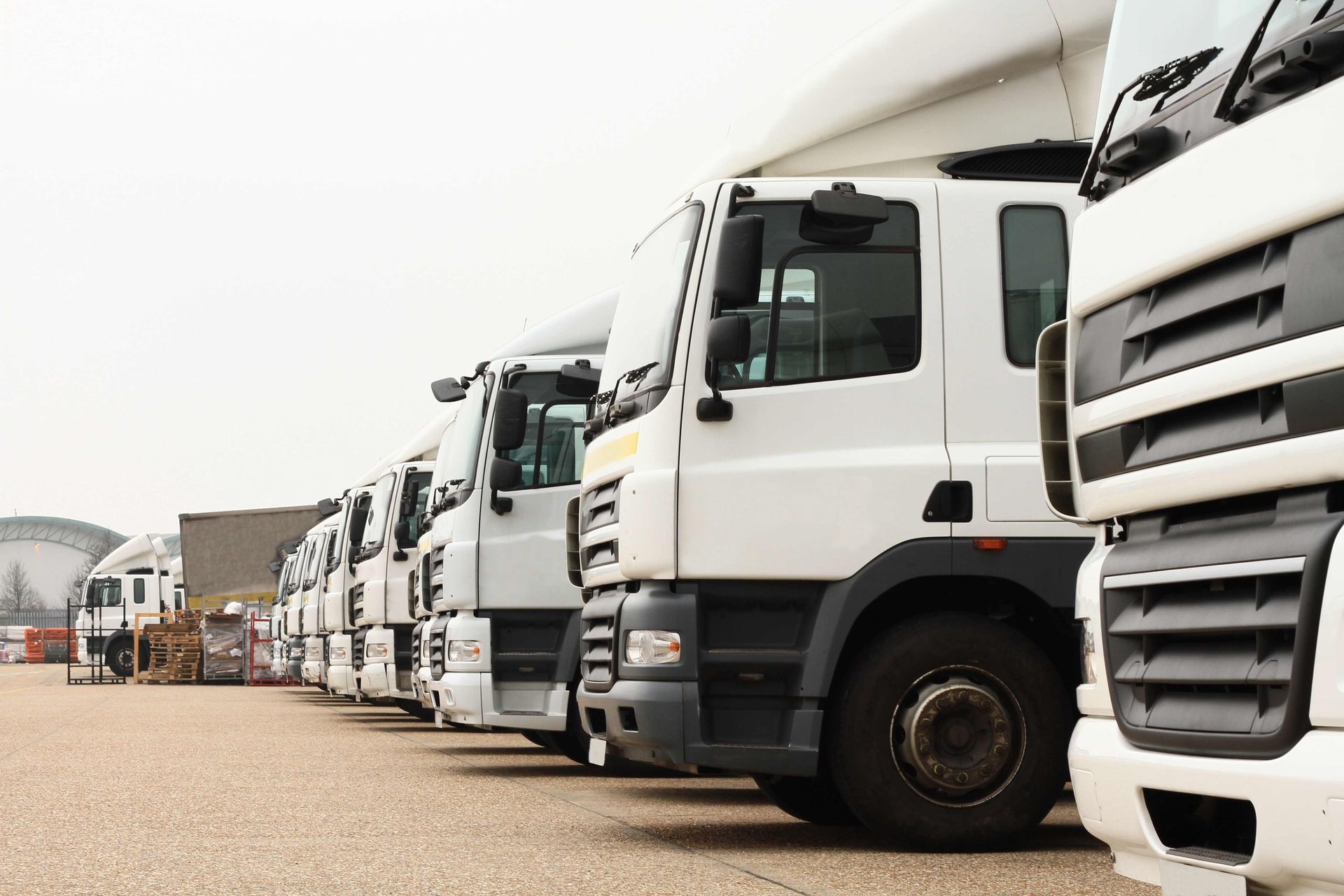 a row of semi trucks are parked in a parking lot