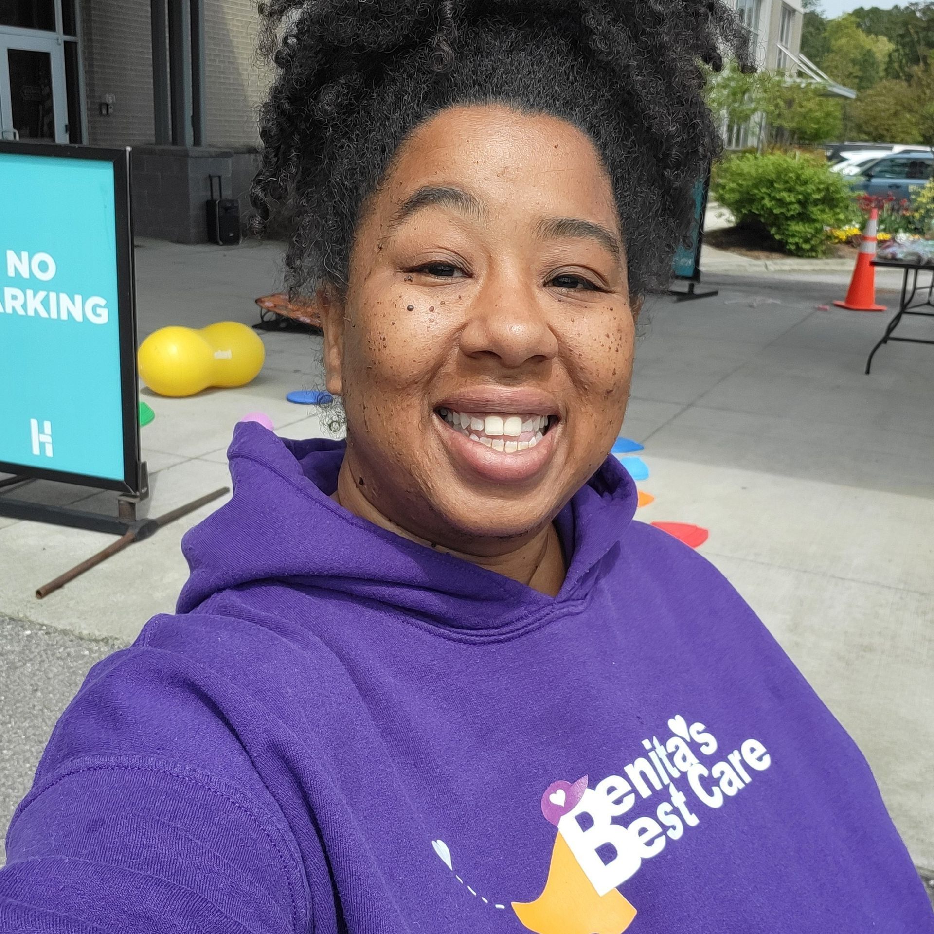 A woman wearing a purple hoodie that says benita 's best care