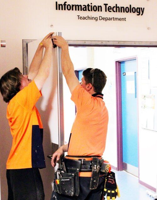 Two Men Measuring A Door Frame - Door Specialist in Wauchope, NSW