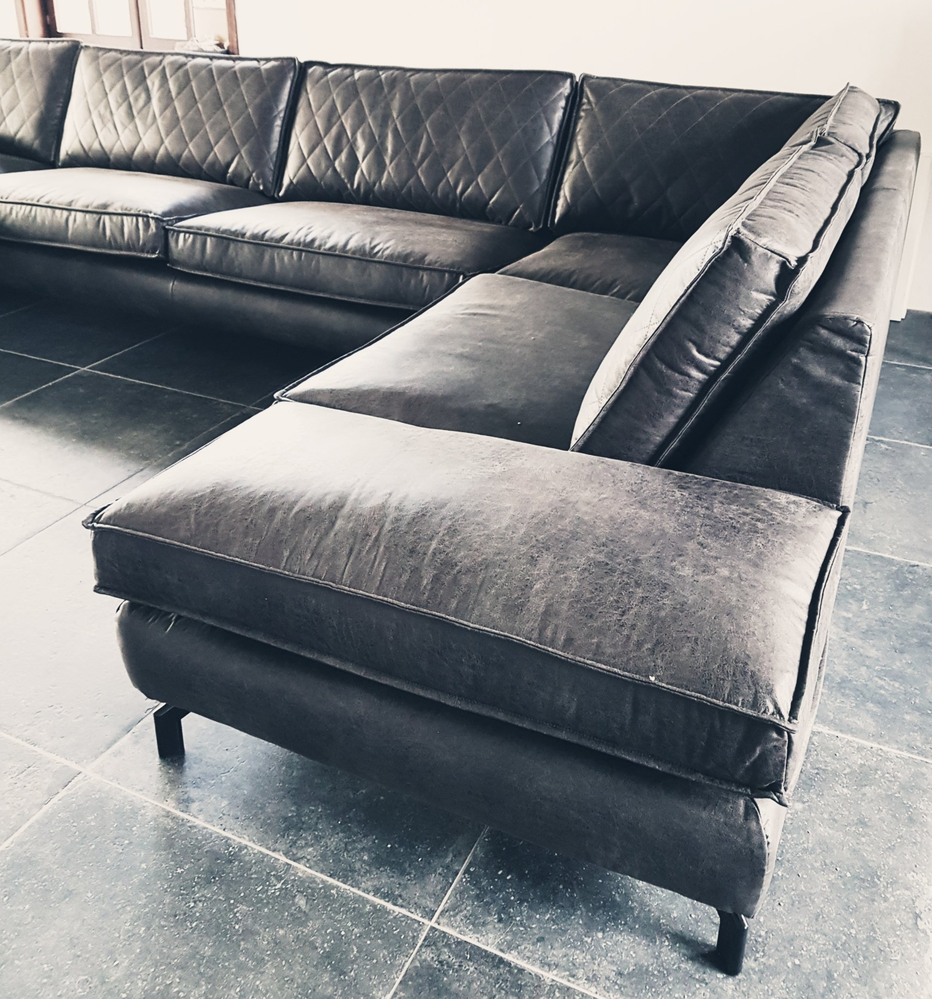 Antraciet hoekbank in microleder met ruitstiksel en metalen poot