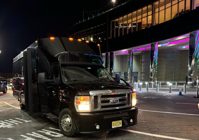 A black van is parked in front of a building at night.