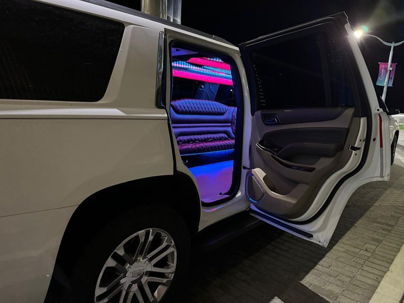 A white suv with its doors open is parked on the side of the road.