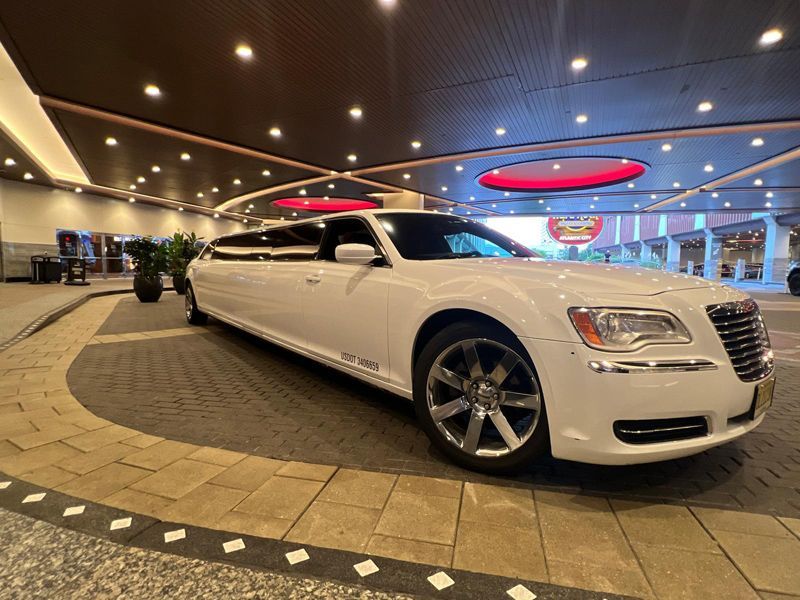 A white limousine is parked in the lobby of a hotel.