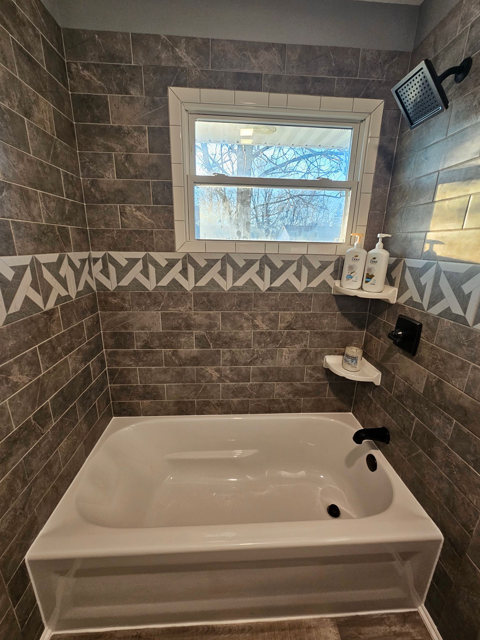 A bathroom with a bathtub and a window.