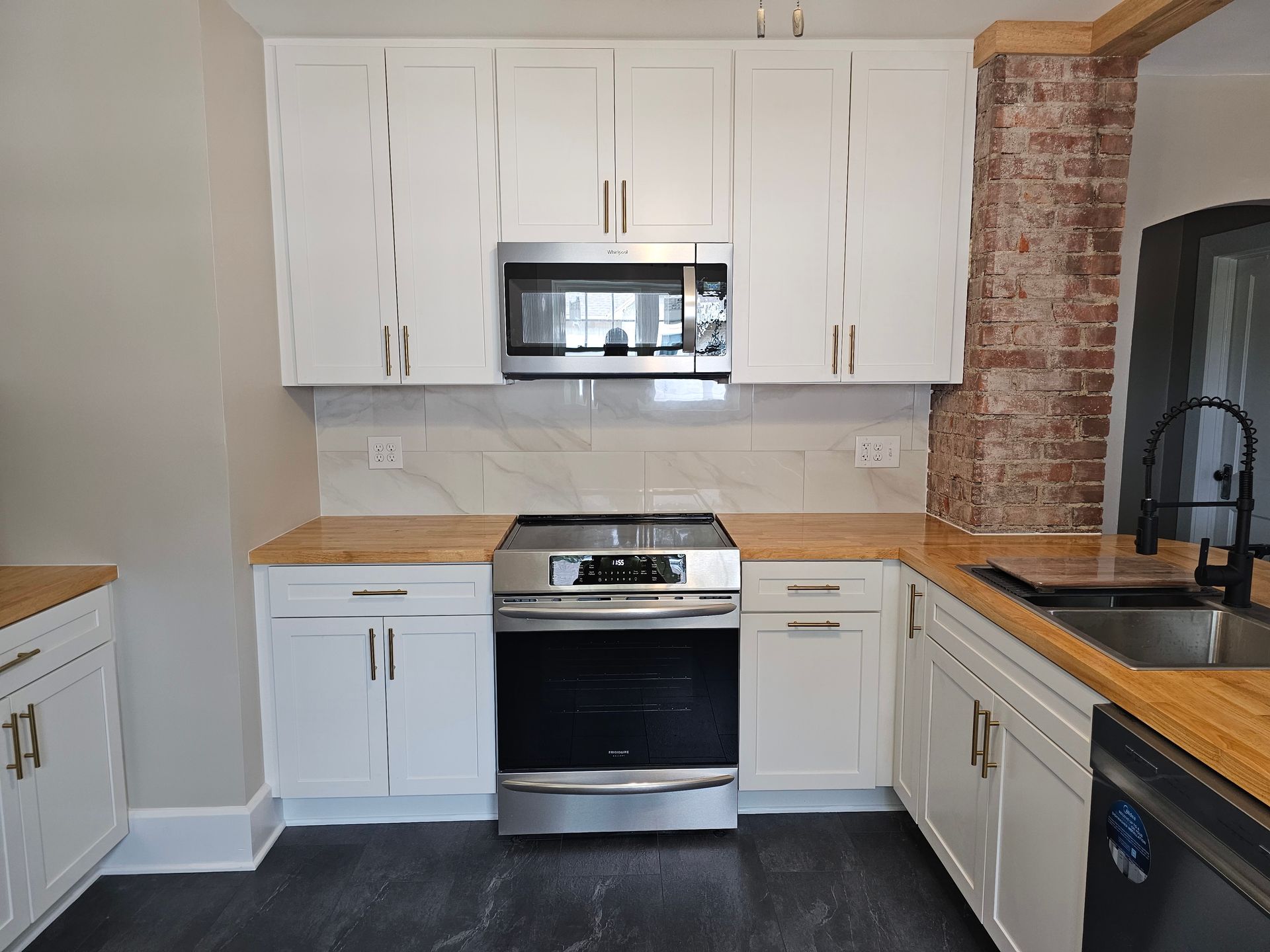 A kitchen with white cabinets and stainless steel appliances