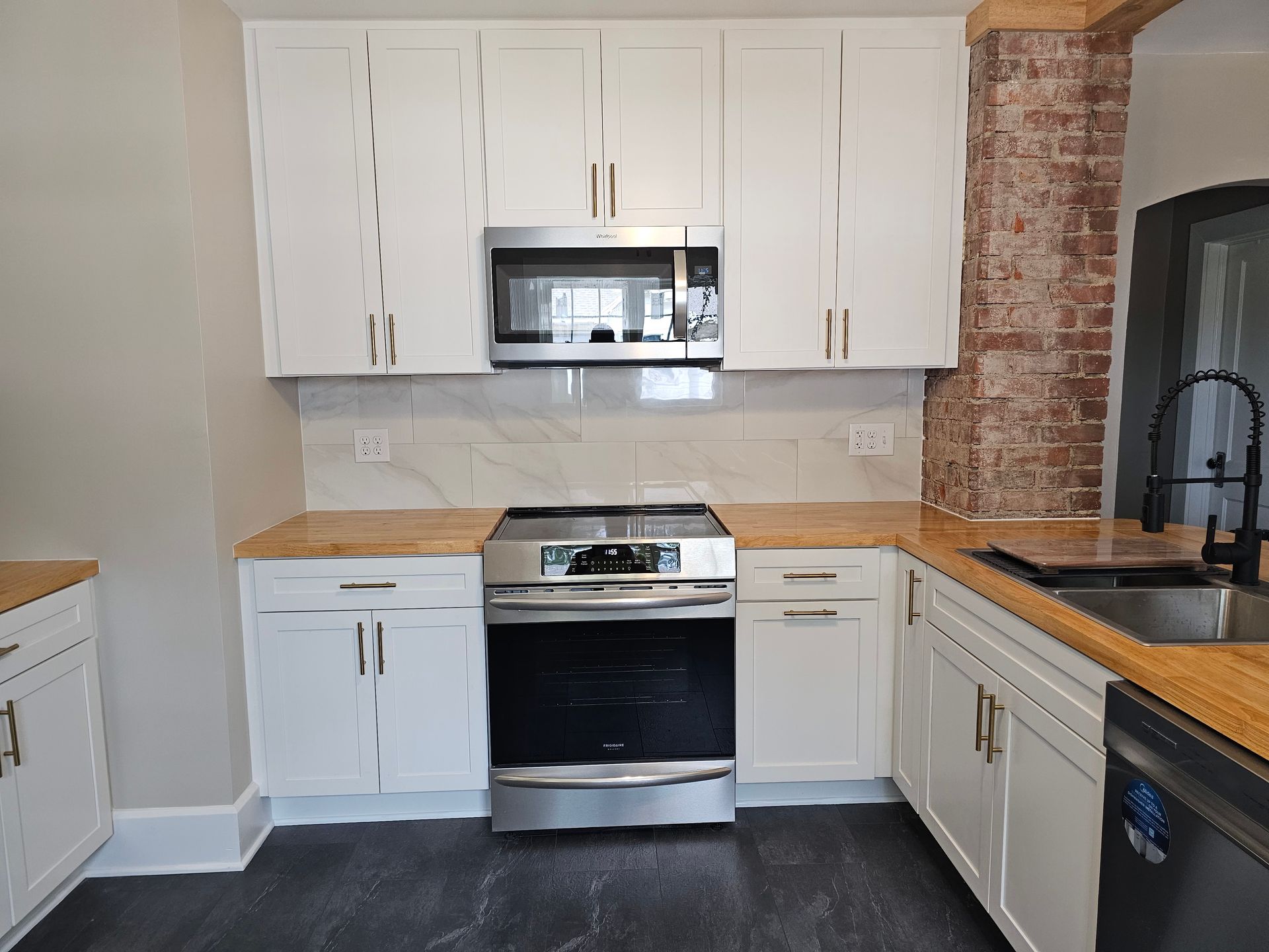 A kitchen with white cabinets and stainless steel appliances