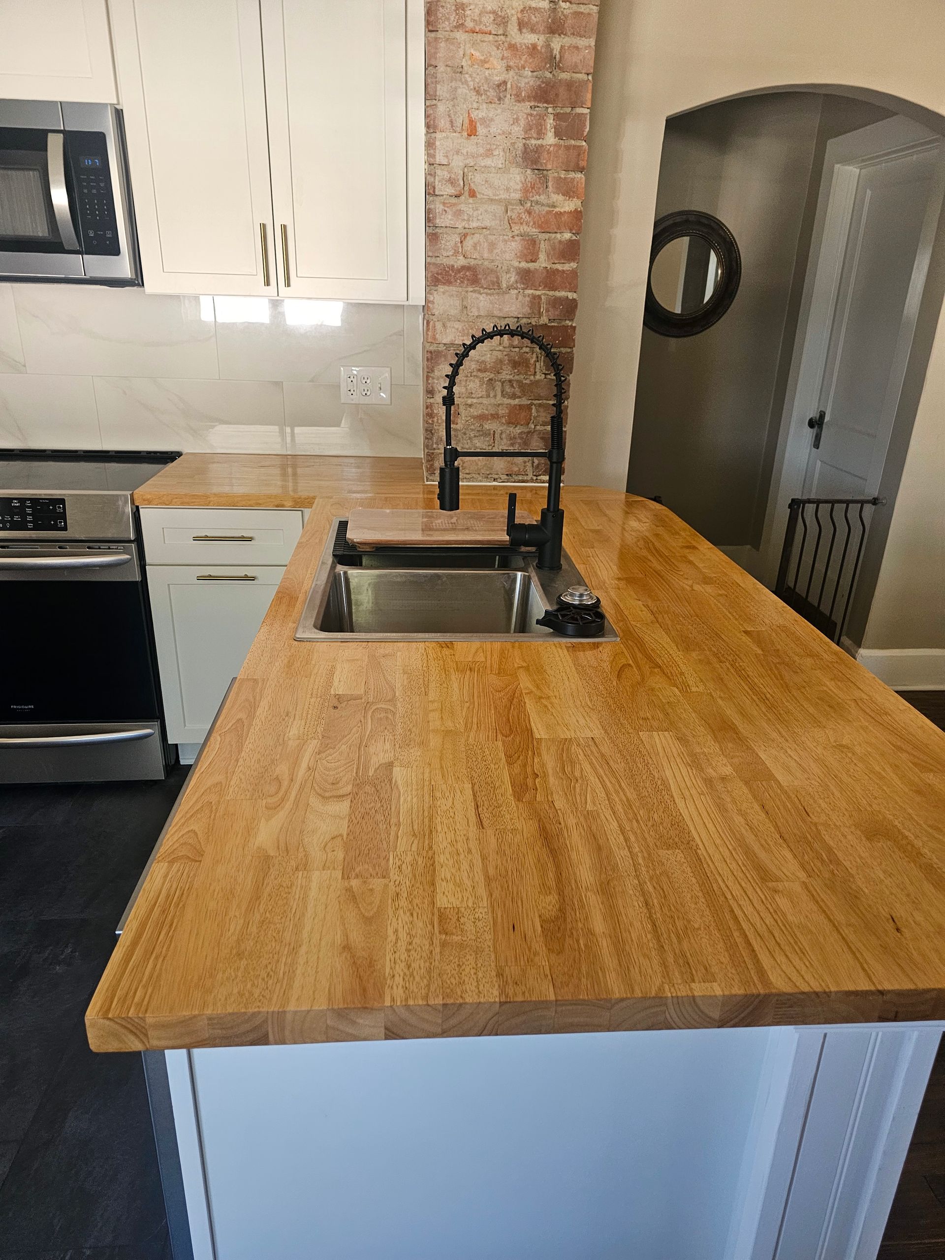 A kitchen with a wooden counter top and a sink.