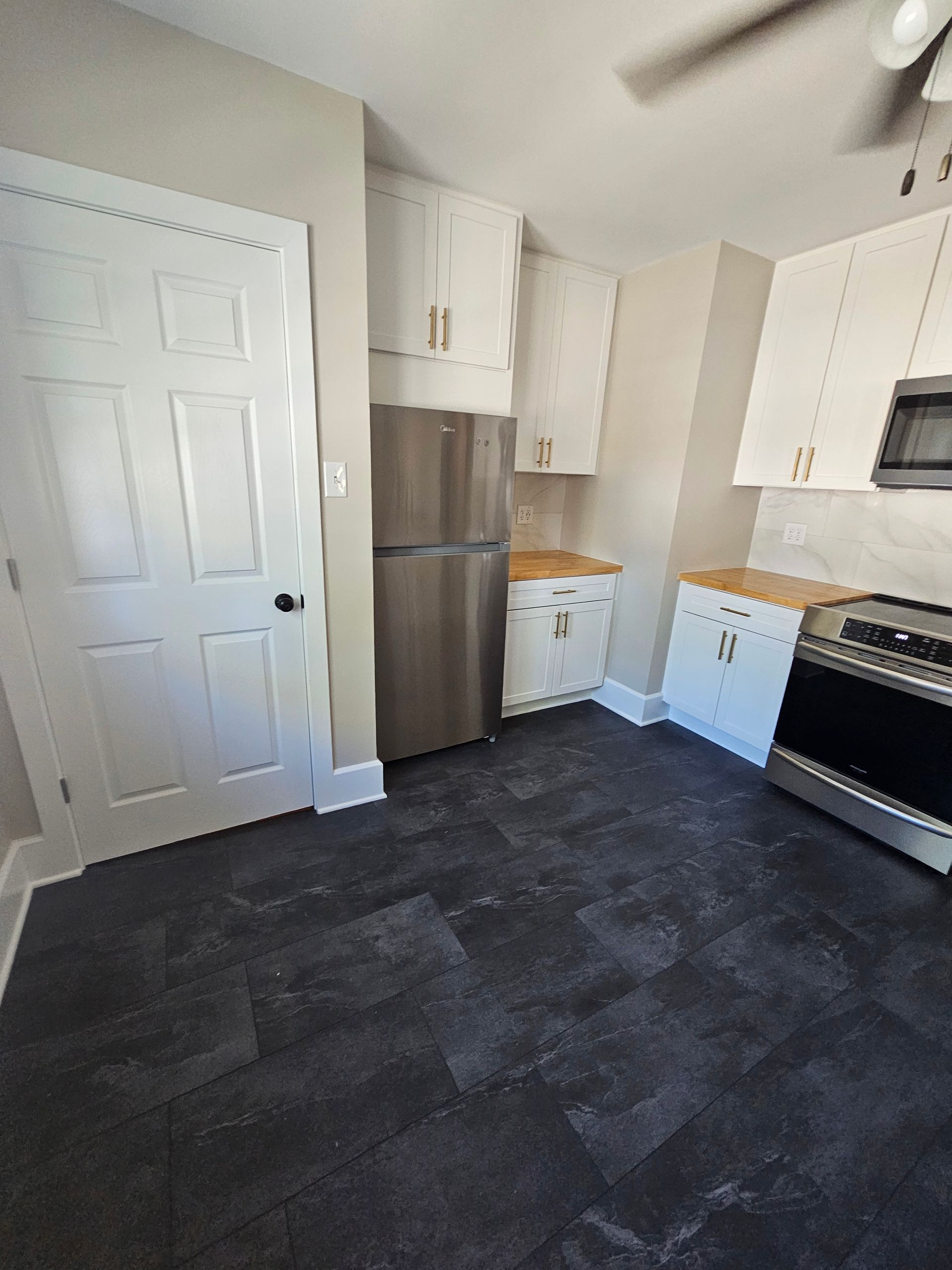 A kitchen with a refrigerator , stove , and microwave.
