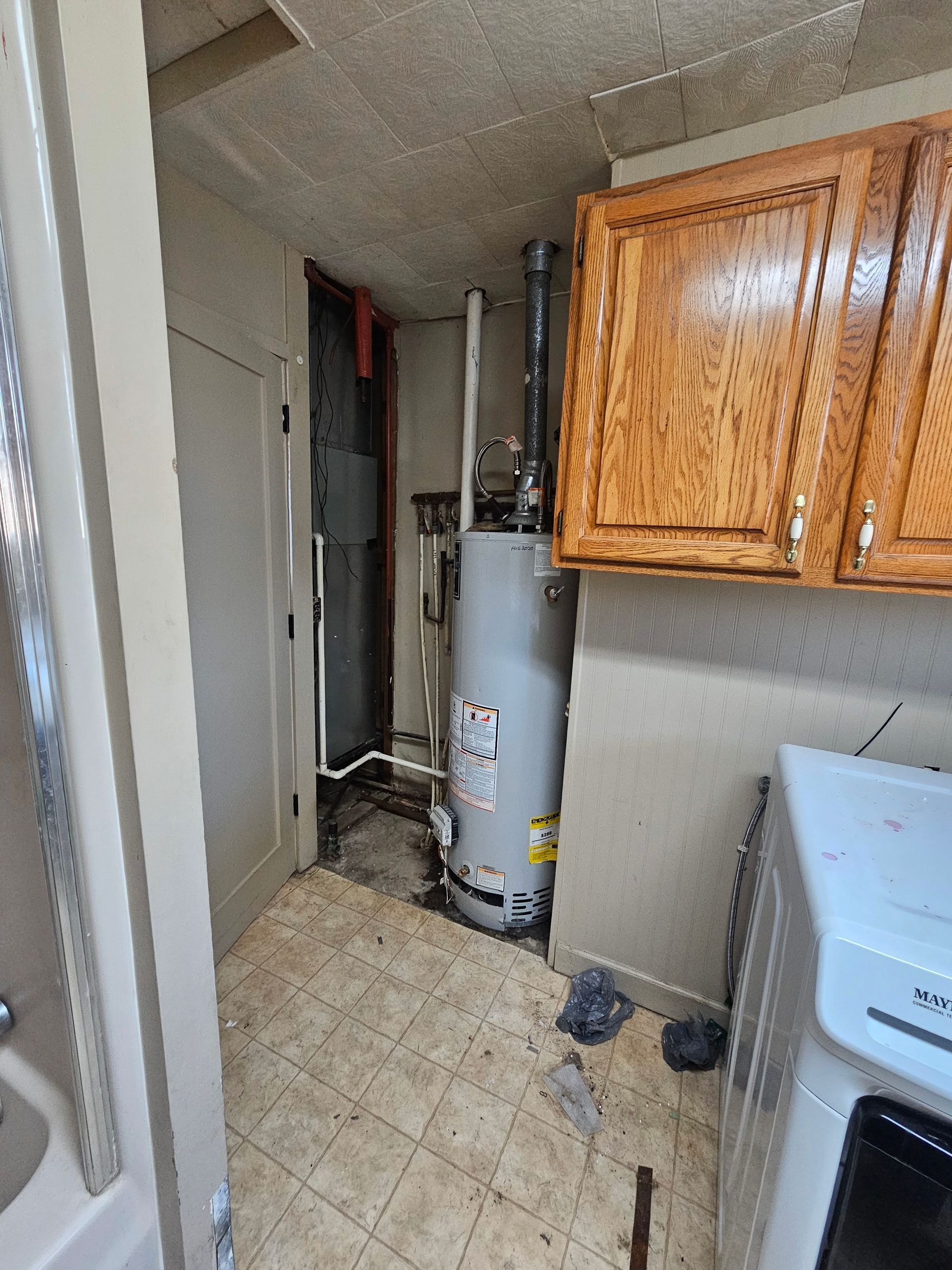 A laundry room with a water heater and a washer and dryer.