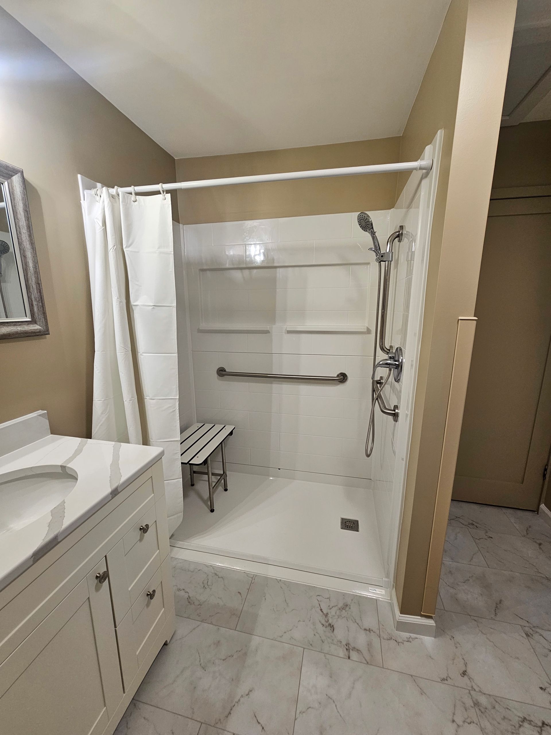 A bathroom with a walk in shower and a sink.